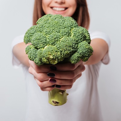 Mens en Gezondheid jonge vrouw met broccoli